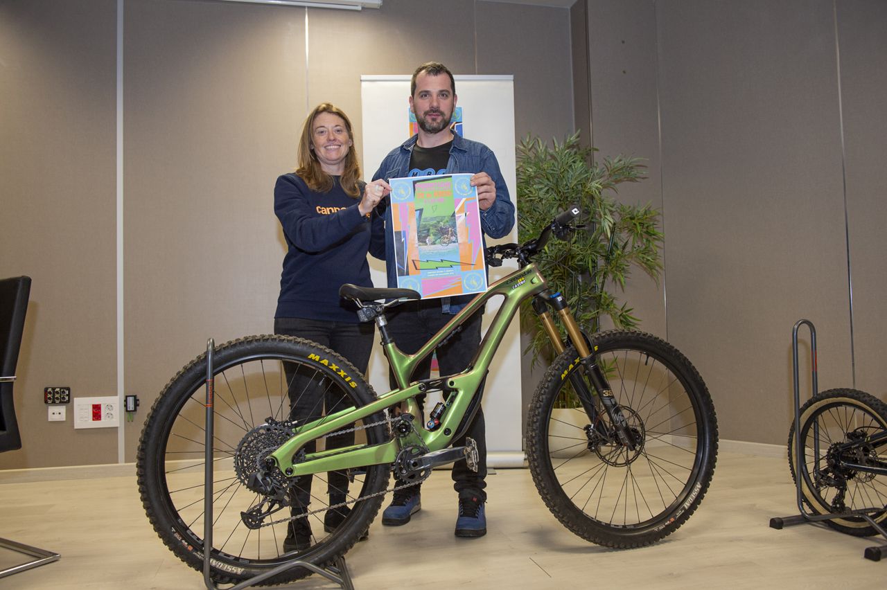 Eva Castro y Aarón Vazquez mostrando el cartel de la Escuela Ciclista del club