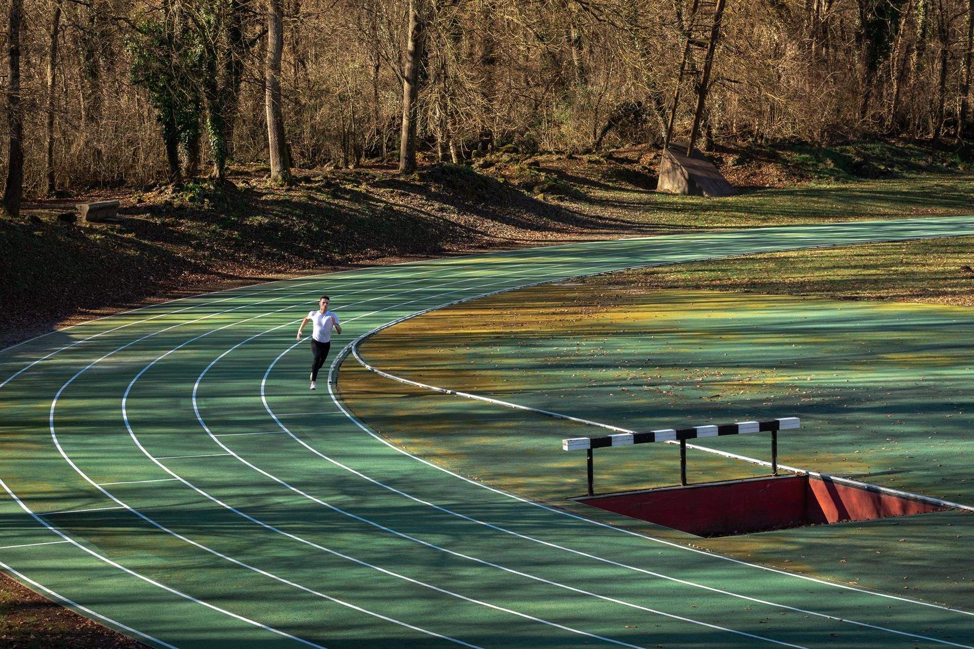 En medio del bosque surge la pista de atletismo de Olot. Un rincón único en el que correr. EFE.