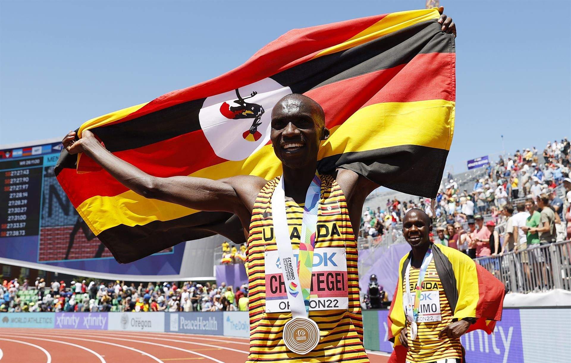Joshua Cheptegei, con Jacob Kiplimo al fondo, celebra su triunfo en los 10.000 metros en Oregón. EFE.