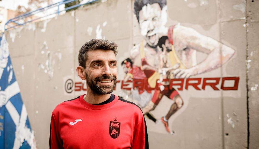  Miguel del Pozo posando delante del mural del héroe del barrio, Fernando Carro. BÁRBARA SÁNCHEZ PALOMERO