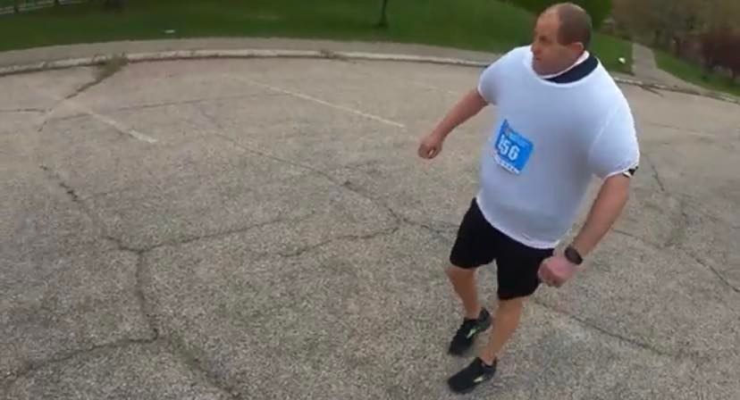 David Rush con las 111 camisetas que le han dado el récord Guinness de medio maratón