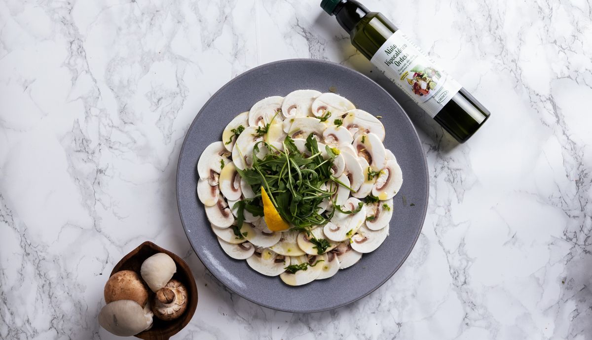 Carpaccio de champiñones con con toque cítrico y rúcula cenital Carpaccio de champiñones con con toque cítrico y rúcula cenital