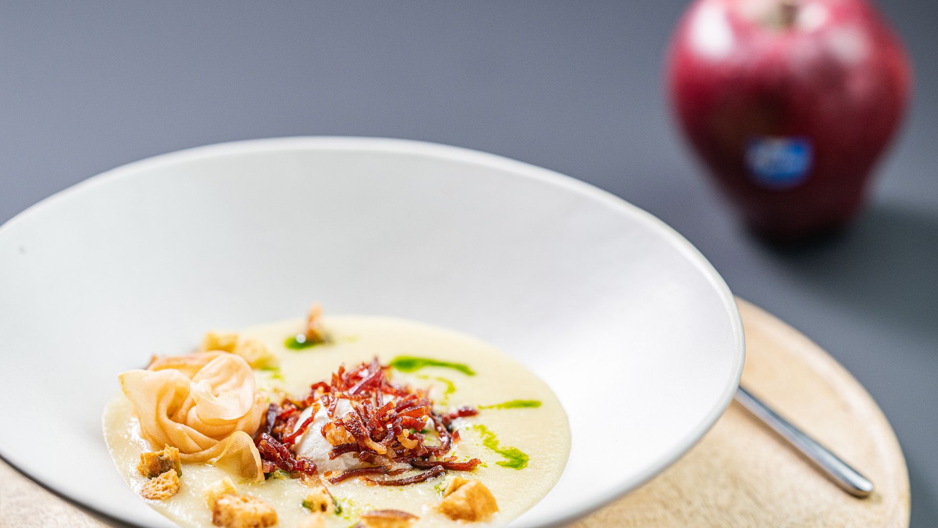 Crema de red delicious Marlene® y apio, con huevo escalfado, tiras de jamón y flor de manzano. ©www.wisthaler