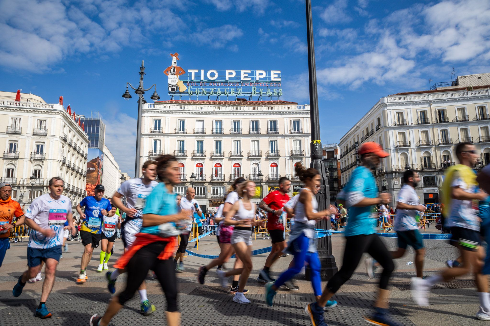 Participantes del Movistar Madrid Medio Maratón a su paso por la Puerta del Sol.