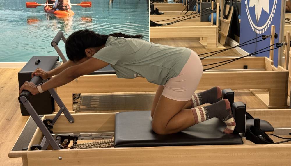 Knee Stretch con brazos paralelos al suelo