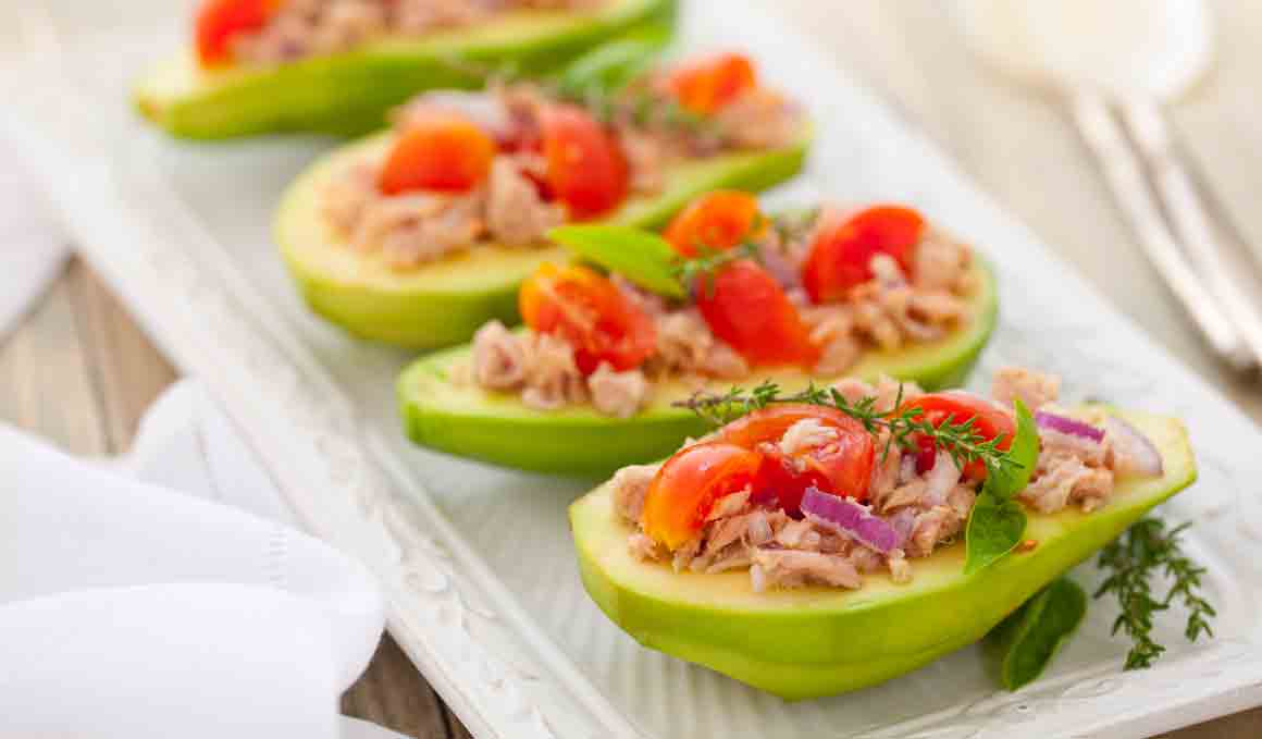 Cena fitness de aguacates rellenos de atún, tomate y anchoas