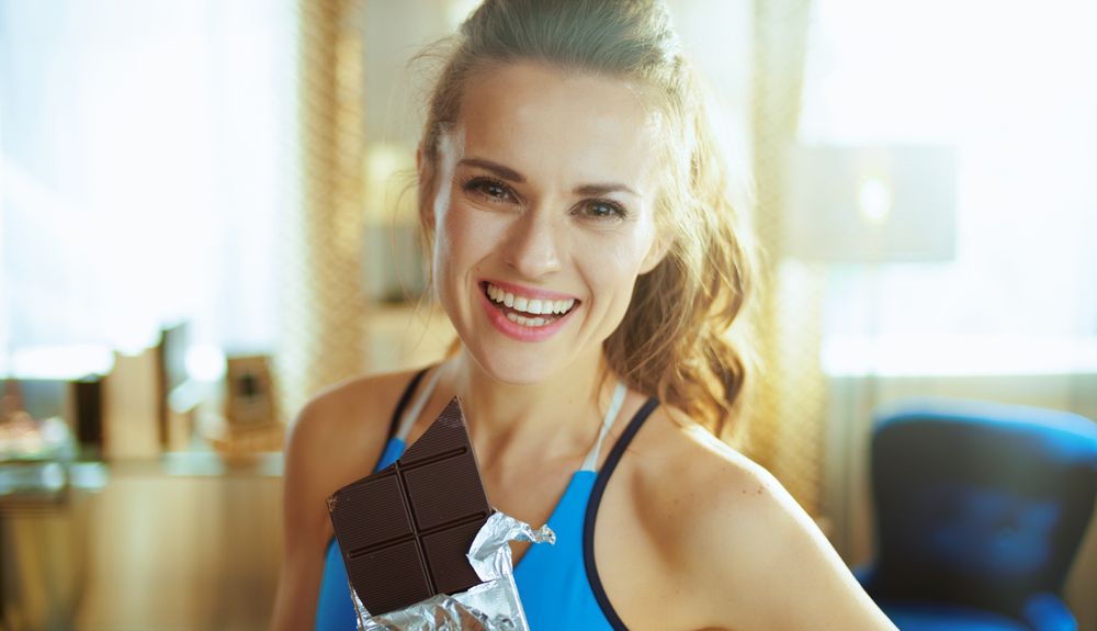 mujer deportista comiendo chocolate beneficios