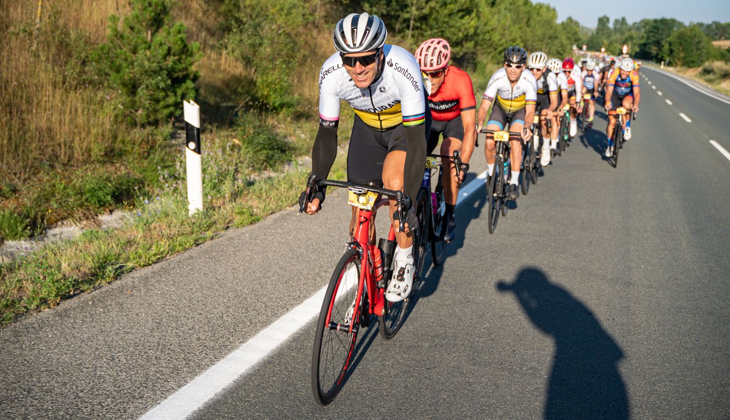 De Genis Zapater vemos su sombra... va por delante de un grupo en fila india comandado por Indurain, ¡haciendo fotos!
