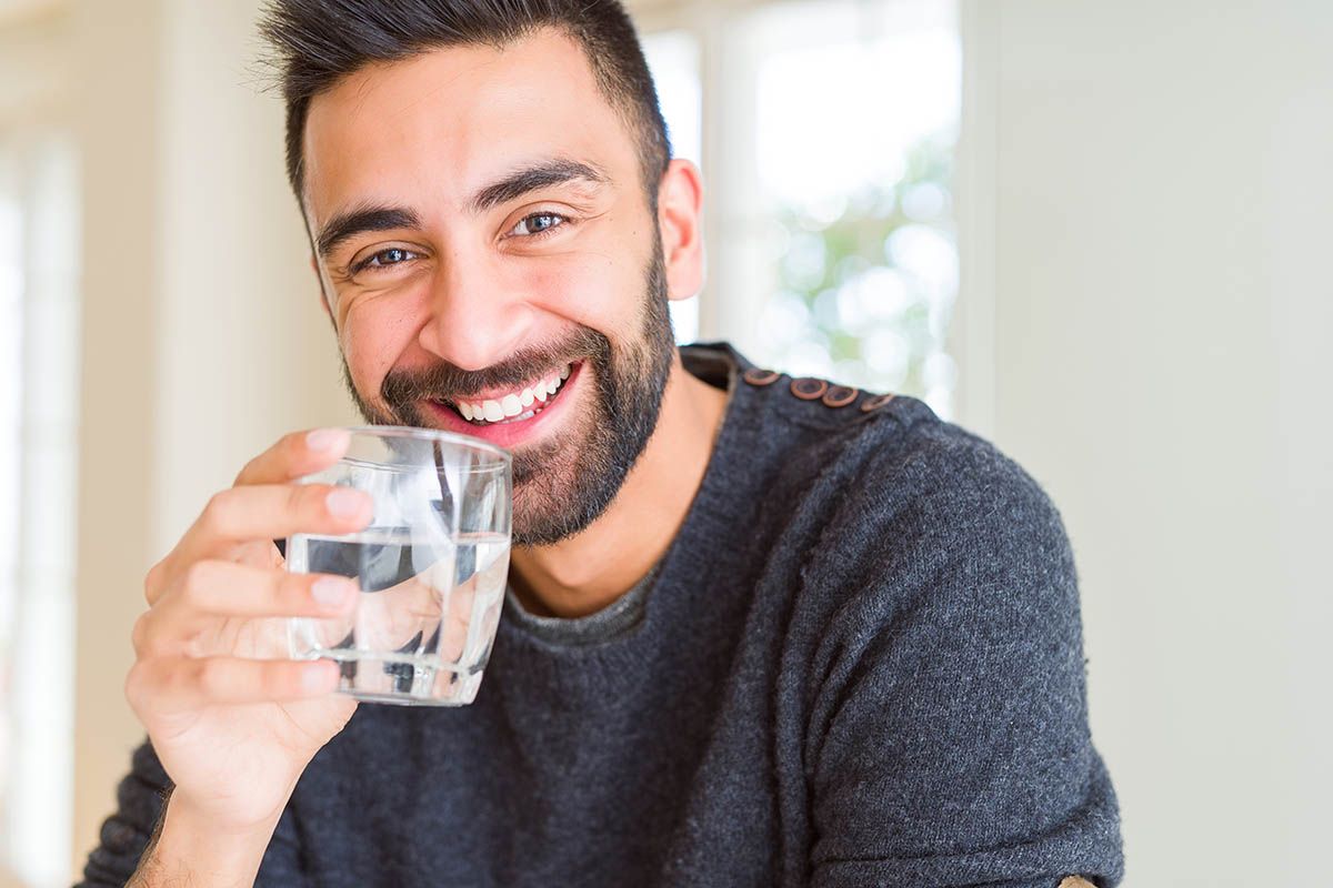 hombre bebiendo agua iStock 1205747173